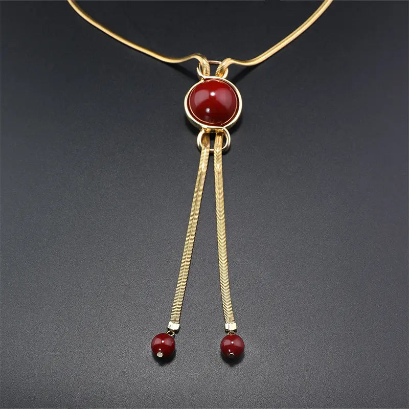 Parure de bijoux élégante en pierre rouge et pampilles dorées pour dîners de gala
