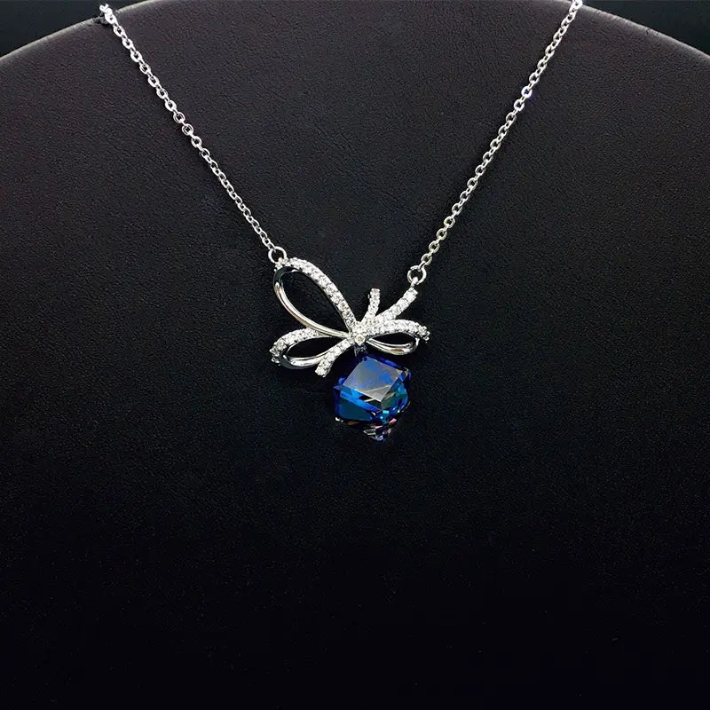 Chic collier doré avec nœud en cristal bleu pour une sophistication au quotidien