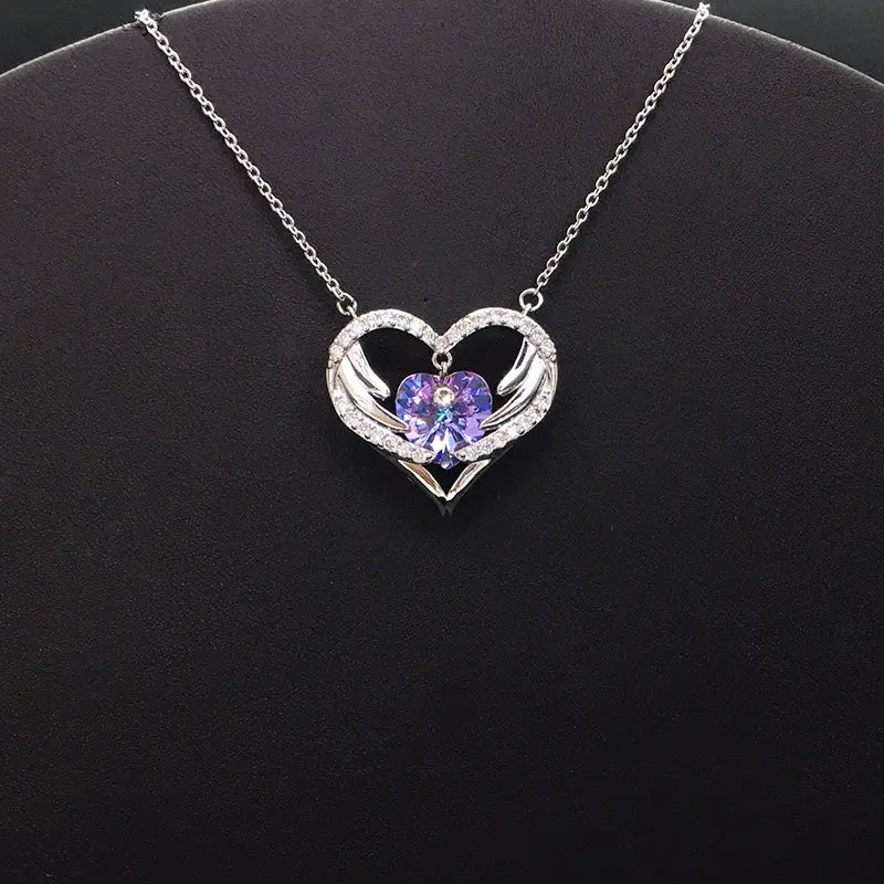 Élégant collier en forme de cœur argenté avec cristal violet et ailes pour galas de soirée