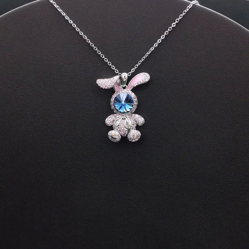 Élégant pendentif lapin argenté avec des accents roses et un visage en cristal bleu pour un style décontracté et enjoué