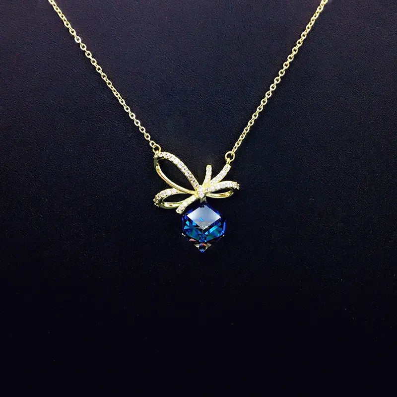 Chic collier doré avec nœud en cristal bleu pour une sophistication au quotidien