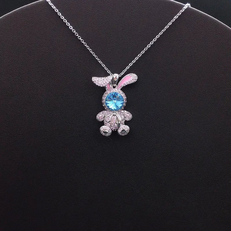 Élégant pendentif lapin argenté avec des accents roses et un visage en cristal bleu pour un style décontracté et enjoué