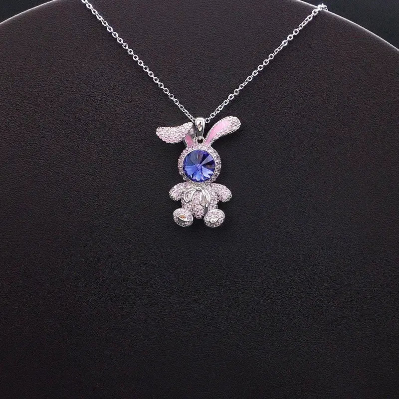 Élégant pendentif lapin argenté avec des accents roses et un visage en cristal bleu pour un style décontracté et enjoué