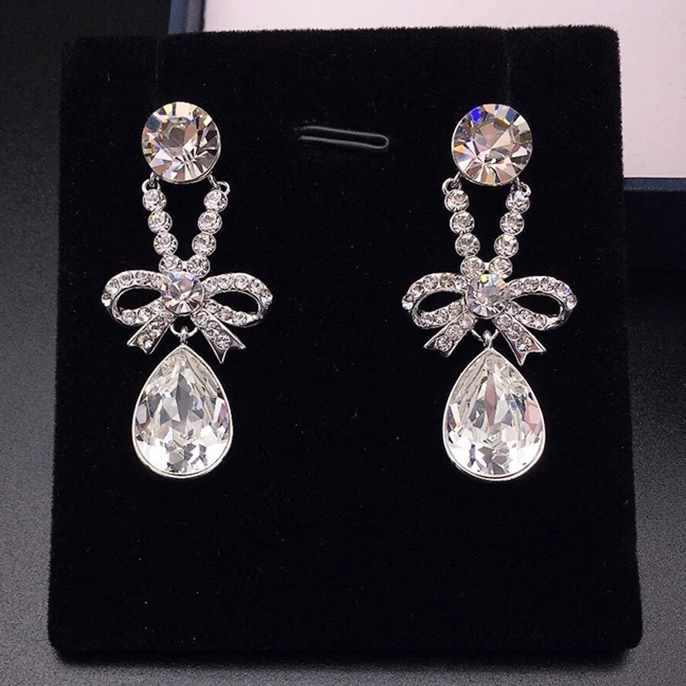 Boucles d'oreilles pendantes élégantes avec nœud en cristal violet pour femmes