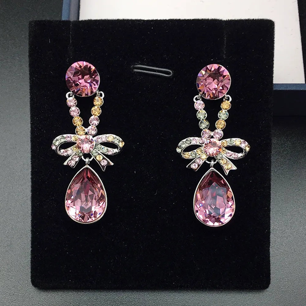 Boucles d'oreilles pendantes élégantes avec nœud en cristal violet pour femmes