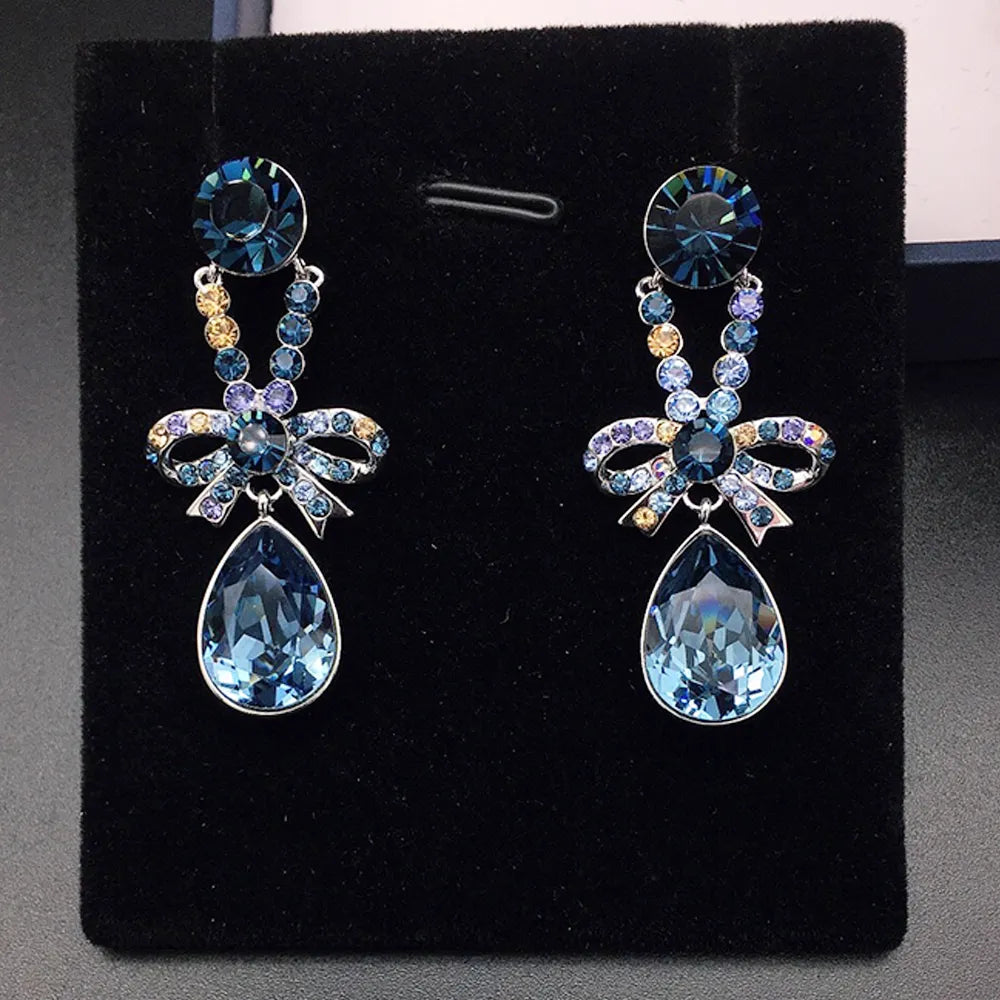 Boucles d'oreilles pendantes élégantes avec nœud en cristal violet pour femmes