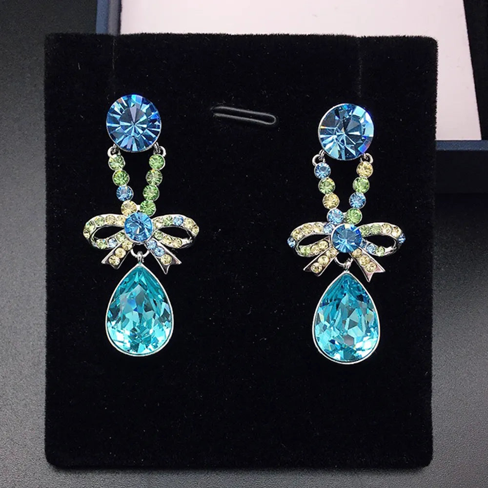 Boucles d'oreilles pendantes élégantes avec nœud en cristal violet pour femmes